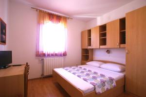 a small bedroom with a bed and a window at Apartment Andrina in Vantačići