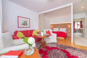 a living room with a red couch and a red bed at Pension Seehof Appartements in St. Wolfgang