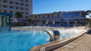 uma piscina com uma fonte em frente a um edifício em Hotel Terme Marconi em Montegrotto Terme