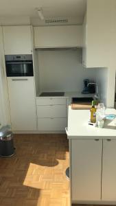 cocina con armarios blancos y suelo de madera en Gezellig 1 slaapkamer appartement nabij het stadscentrum, en Hasselt