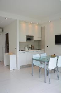 a kitchen with white cabinets and a table and chairs at Club Nautico - Phoenix Studio Lake View in Riva del Garda