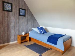 a bedroom with a bed with blue sheets and a table at Clos Margottières in Le Val-Saint-Père