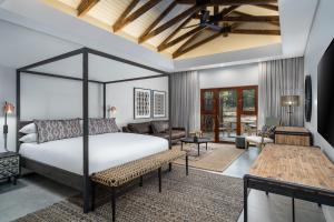 a bedroom with a bed and a living room at Kruger Gate Hotel in Skukuza