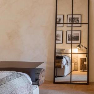 a bedroom with a large mirror and a bed at Argiano Dimore Wine Relais in Argiano