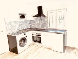 a kitchen with a washing machine and a sink at Super Exclusive Bungalow in Benalmádena