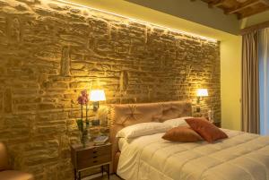 a bedroom with a stone wall with a bed at Villa Antica Dimora intera struttura - Homelike Villas in Deruta +9 photos