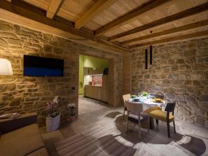 uma sala de jantar com uma mesa e uma parede de pedra em Villa Antica Dimora intera struttura - Homelike Villas em Deruta