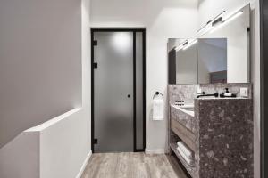 
a bathroom with a sink and a door at NLH MONASTIRAKI - Neighborhood Lifestyle Hotels in Athens
