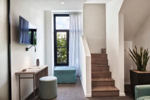 a living room with a staircase and a window at NLH MONASTIRAKI - Neighborhood Lifestyle Hotels in Athens