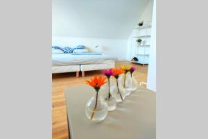 a row of vases with flowers on a table in a room at Charming holiday home near top beaches and ports in Penmarcʼh