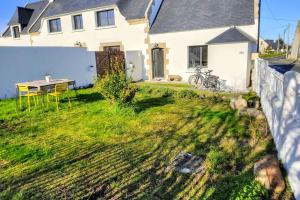 a house with a yard with a table and a fence at Charming holiday home near top beaches and ports in Penmarcʼh