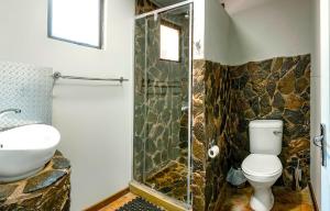 y baño con ducha, aseo y lavamanos. en Orange River Rafting Lodge, en Kotzeshoop