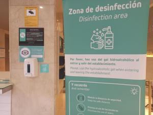 a sign in a building with a sign for a disinfection sign at Hotel Alda Jolio Jaca in Jaca