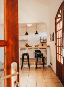 a kitchen with two black stools in a room at Résidence de tourisme Domaine Saint-François in Saint-François