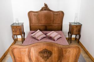 ein Schlafzimmer mit einem Holzbett mit zwei Nachttischen in der Unterkunft Pałac Wielka Wieś - "Pałac pod Dębem" in Główczyce