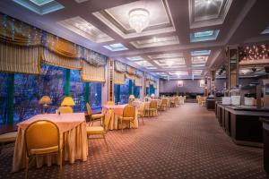- une salle à manger avec des tables, des chaises et des fenêtres dans l'établissement Park Inn by Radisson Poliarnie Zori, à Mourmansk
