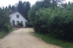 a dirt road in front of a white house at Appartement La Libellule, professionnels et vacanciers in Compreignac