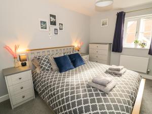 a bedroom with a large bed with blue pillows at Robins Cottage in Evesham