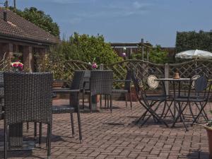 un grupo de sillas y mesas en un patio en Marsham Arms Inn, en Hevingham