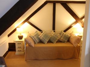 een slaapkamer met een bed met kussens erop bij Pilgrims Hotel in Canterbury