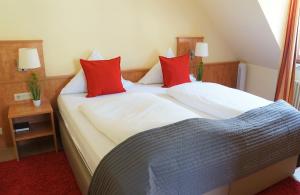 a bedroom with two beds with red pillows at Hotel Bischoff in Baden-Baden