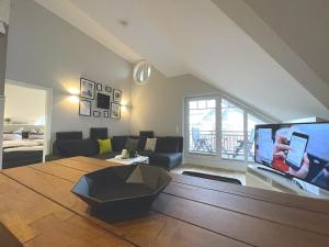 ein Wohnzimmer mit einem Sofa und einem Flachbild-TV in der Unterkunft smûk - Luxus Dachgeschoss in Westerland