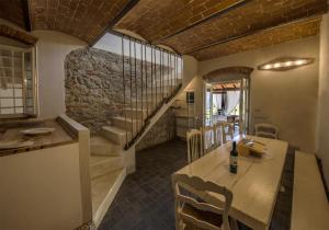 una sala da pranzo con tavolo e scala di Villa Chianti - Homelike Villas a Terranuova Bracciolini