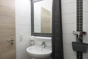 a bathroom with a sink and a mirror at Haus Klaarstrand in Wenningstedt