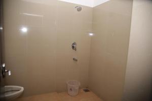 uma casa de banho com um chuveiro e um WC. em MEGHNA RESIDENCY em Trivandrum