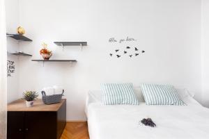 Un dormitorio con una cama blanca con pájaros en la pared en Secret House, en Brasov