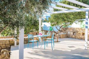 a table and chairs under a white pergola at Villa il Cristallo - Homelike Villas in Torricella