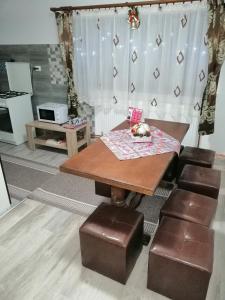 comedor con mesa y algunas sillas marrones en Casa Alex, en Topliţa