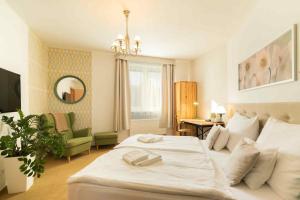 - une chambre avec un grand lit blanc et une chaise dans l'établissement Penzion Uno, à Zlín