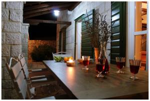 a wooden table with wine glasses on a patio at Villa Kate in Vrsine
