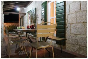 Une table et des chaises en bois sont disponibles sur la terrasse. dans l'établissement Villa Kate, à Vrsine