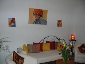 a living room with a couch and a painting on the wall at Riad Irene in Marrakesh