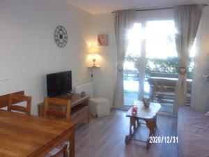 Hébergement Coup de Coeur في آكس ليه تيرم: غرفة معيشة مع أريكة وطاولة