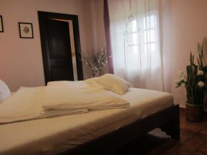 - un lit avec des draps blancs dans une chambre avec une fenêtre dans l'établissement Tenuta Seripa, à Sassetta