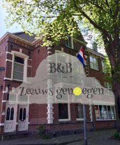 a brown brick building with a flag in front of it at Appartement Zeeuws genoegen in Vlissingen