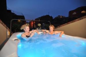 two women sitting in a hot tub drinking wine at Chester Apartments in Chester