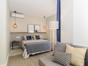 a bedroom with a bed and a couch at Sitges Spaces Deluxe Centre Apartment in Sitges