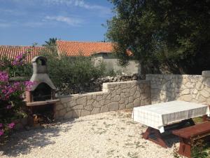 a backyard with a stone wall and a pizza oven at Apartments Mira 1434 in Lun