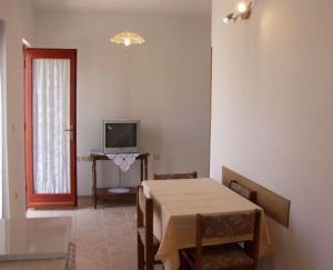 ein Esszimmer mit einem Tisch und einem TV in der Unterkunft Apartments Mira 1434 in Lun