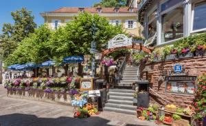 une rue avec un marché aux fleurs devant un bâtiment dans l'établissement Hotel zum Goldenen Löwen, à Baden-Baden