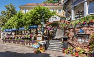 eine Straße mit einem Blumenmarkt vor einem Gebäude in der Unterkunft Hotel zum Goldenen Löwen in Baden-Baden