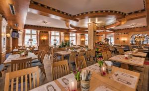 restauracja z drewnianymi podłogami, stołami i krzesłami w obiekcie Hotel zum Goldenen Löwen w Baden-Baden