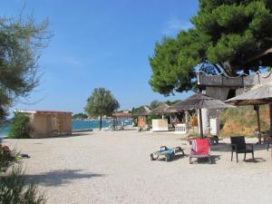 a beach with chairs and umbrellas on the beach at Holiday house Damir in Sveti Filip i Jakov
