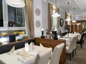 a restaurant with white tables and white chairs at Hotel Restaurant Alt Pirmasens in Pirmasens
