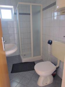 Un baño blanco con inodoro y lavabo. en Holiday house Damir, en Sveti Filip i Jakov