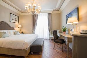 Habitación de hotel con cama, escritorio y escritorio. en Castello Bonaria Wine & Spa Resort en Campiglia Marittima